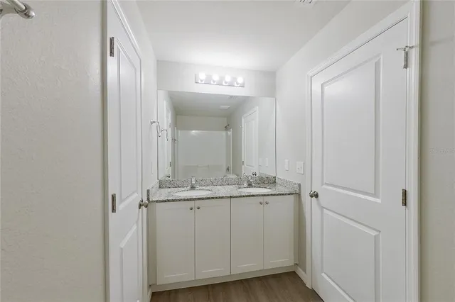 a bathroom with a granite countertop sink and a mirror