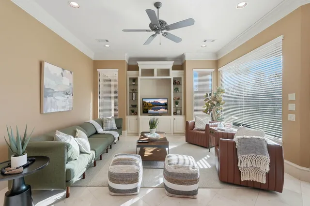 a kitchen with stainless steel appliances kitchen island granite countertop a stove a sink a oven a dining table and chairs with white cabinets