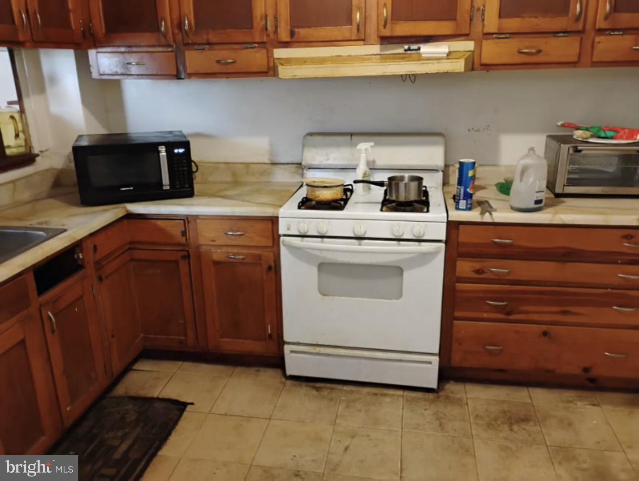 1928 Frederick Avenue Baltimore, MD 21223 - Photo 2 of 6 a kitchen with stainless steel appliances granite countertop a sink a stove and cabinets