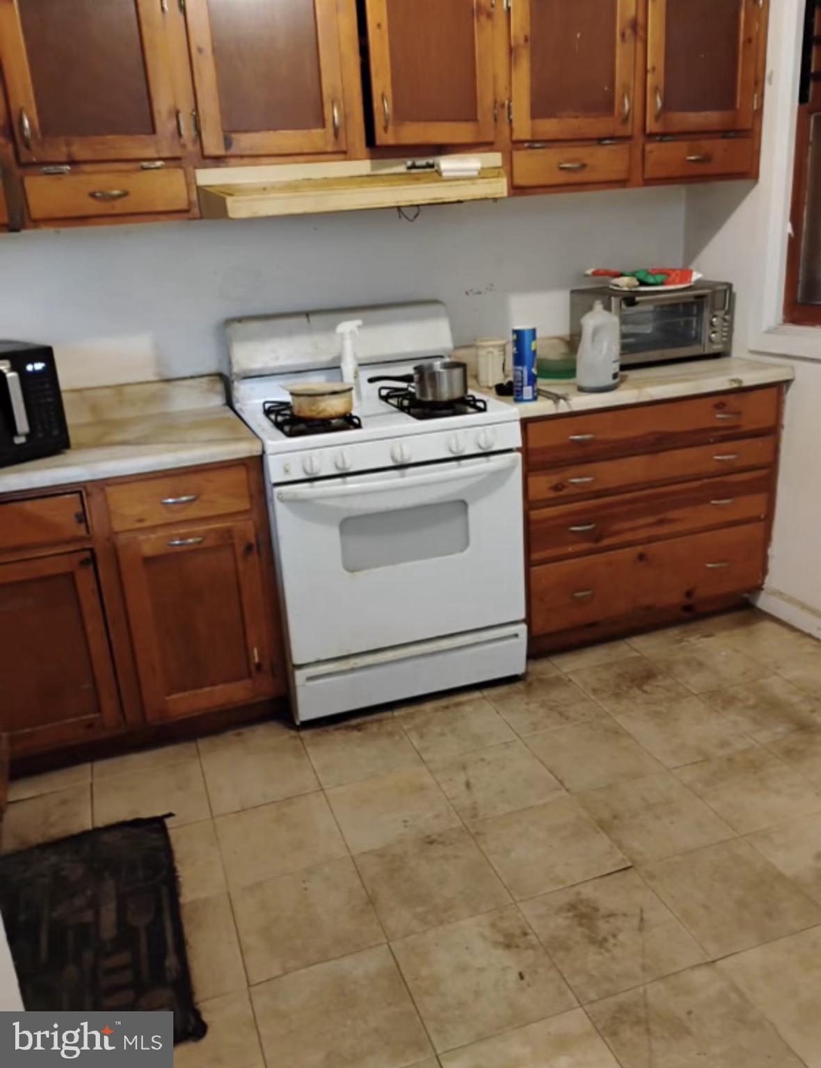 1928 Frederick Avenue Baltimore, MD 21223 - Photo 3 of 6 a kitchen with a cabinets and white stove