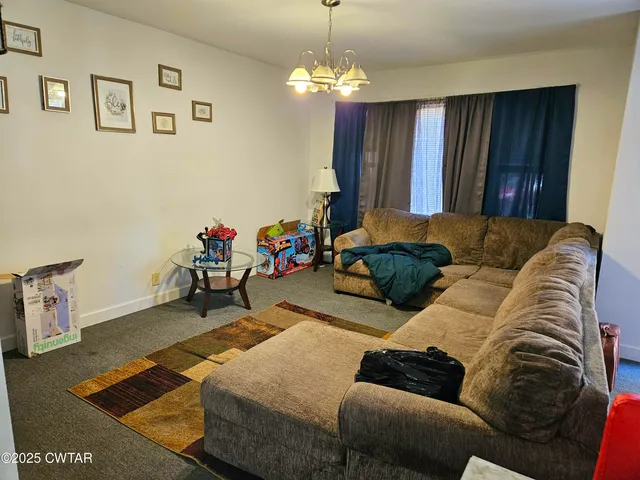 a living room with furniture and a chandelier