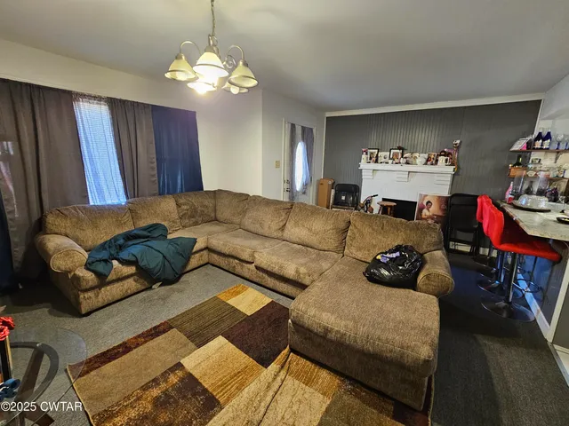 a living room with furniture and a chandelier
