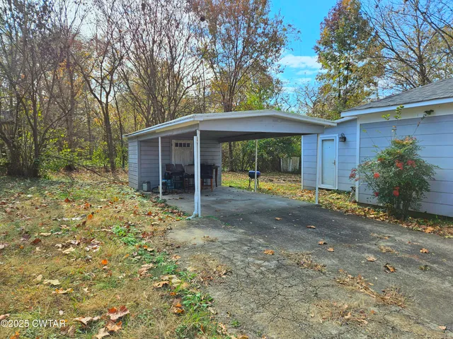 a view of a house with a yard and large tree