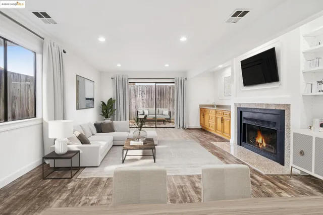 a living room with furniture a fireplace and a flat screen tv