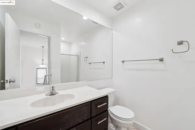 a bathroom with a sink a toilet a light fixture and a mirror