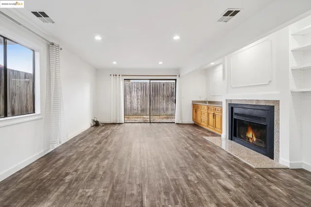 a view of an empty room with a fireplace and a window
