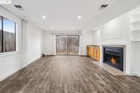 a view of an empty room with a fireplace and a window