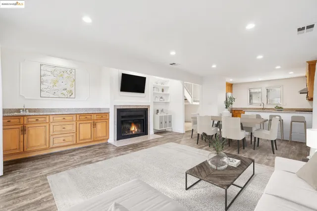 a living room with furniture a fireplace and a kitchen view