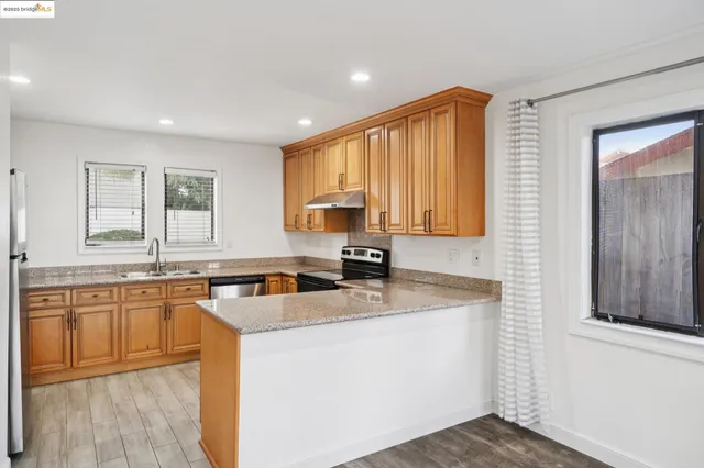 a kitchen with stainless steel appliances granite countertop wooden cabinets a sink and dishwasher
