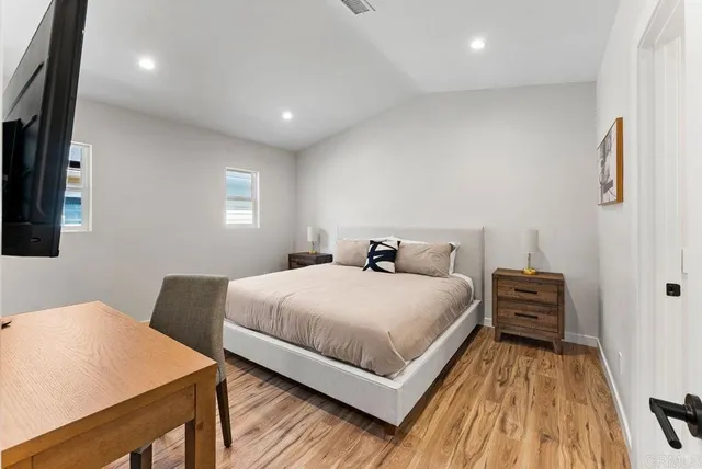 a bedroom with a bed and wooden floor