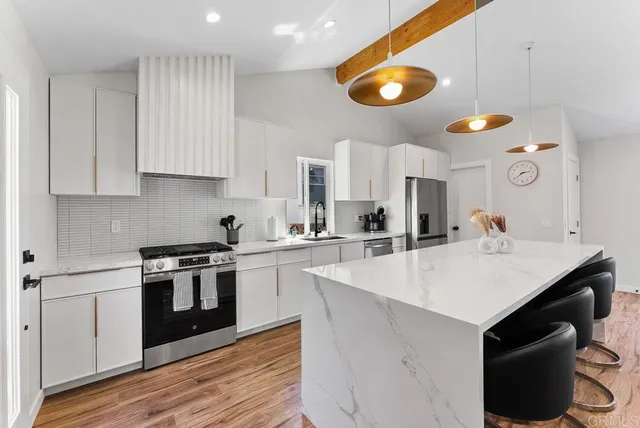 a kitchen with a sink cabinets and wooden floor