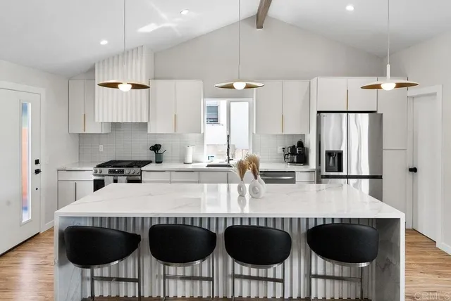 a kitchen with granite countertop a table chairs stove and refrigerator