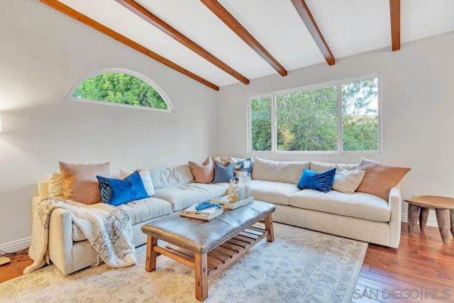 a living room with furniture and a floor to ceiling window