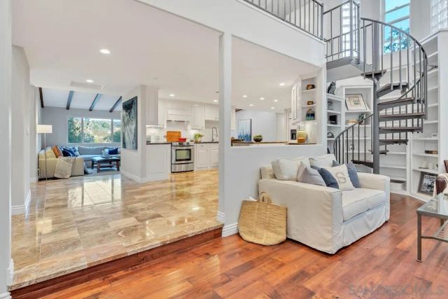 a living room with furniture and a dining table with wooden floor