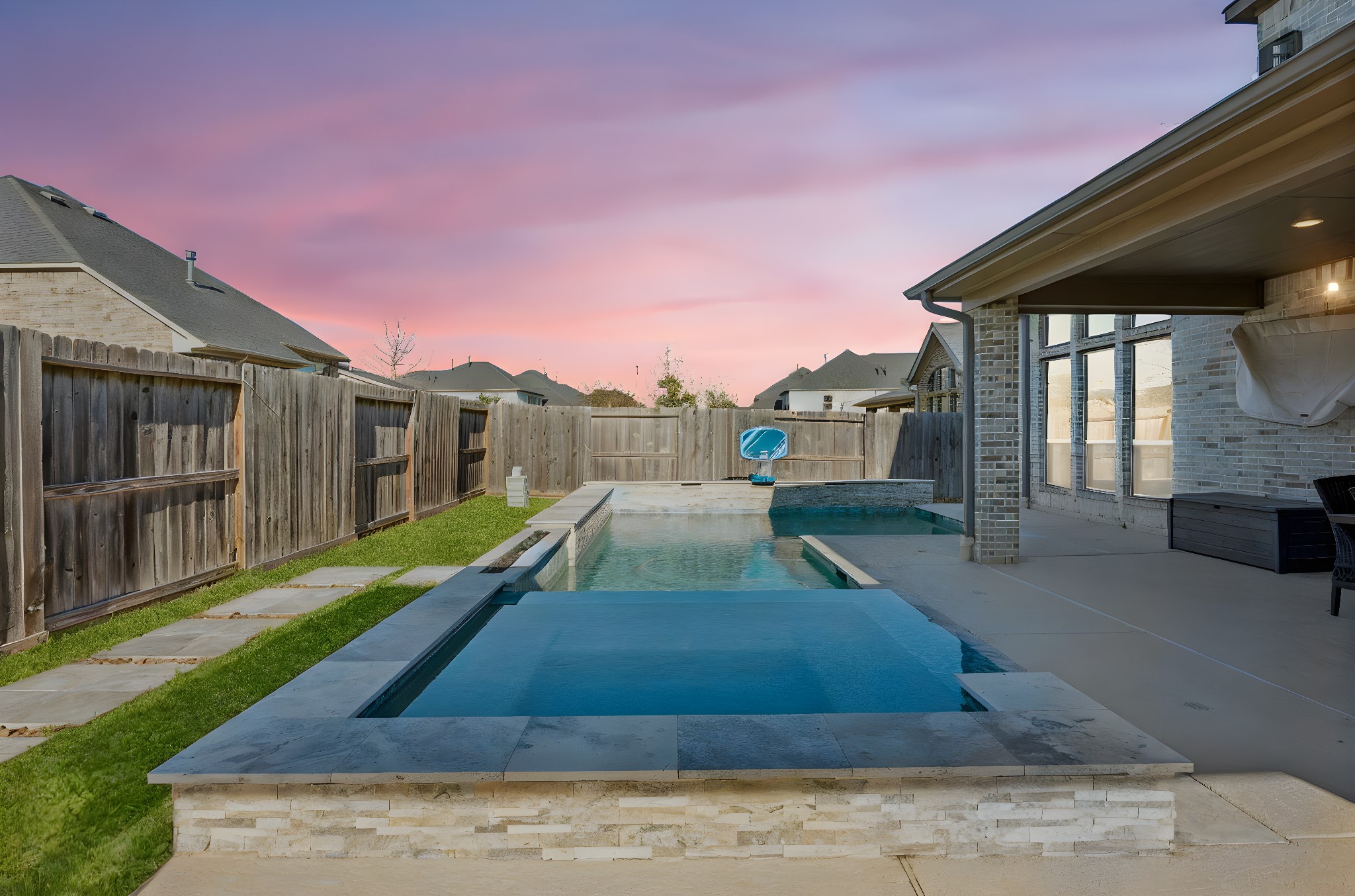 28706 Casen Ranch Lane Fulshear, TX 77441 - Photo 24 of 31 The backyard is fully fenced for ultimate privacy and features professional landscaping with a stone-paved walkway. This tranquil retreat includes a sparkling pool and spa, providing the perfect backdrop for large-scale entertaining or quiet family relaxation.