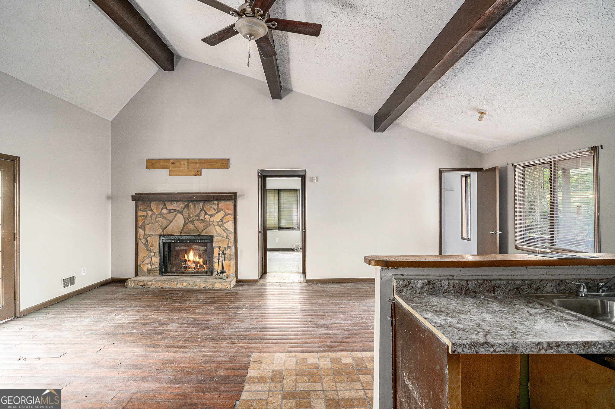 1341 Bethaven Road Riverdale, GA 30296 - Photo 8 of 18 a view of a livingroom with a fireplace a ceiling fan and windows