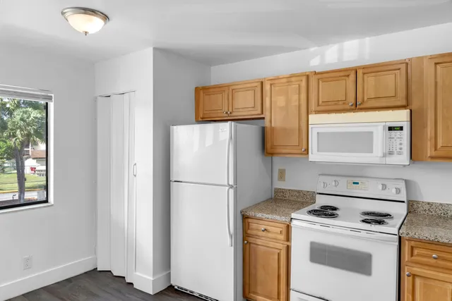 a white refrigerator freezer and a stove sitting inside of a kitchen
