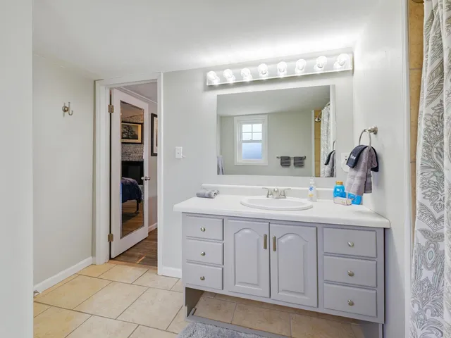 a bathroom with a sink a light fixture a vanity and a mirror