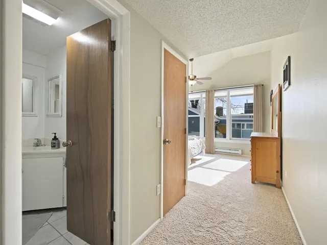 a view of a hallway with living room and wooden floor