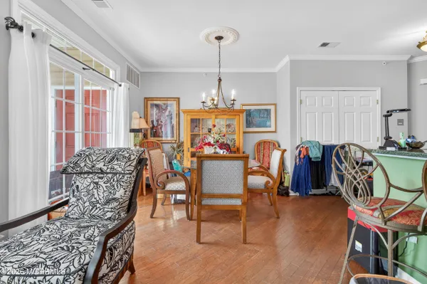 a view of a a dining room with furniture window and wooden floor