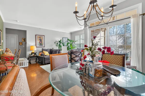 a view of a dining room with furniture a chandelier and wooden floor