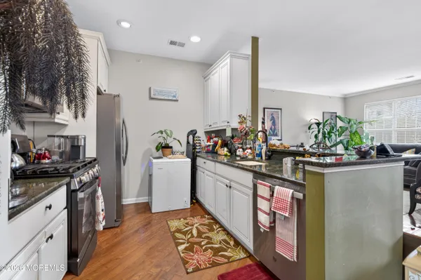 a kitchen with stainless steel appliances granite countertop a stove a sink and a refrigerator