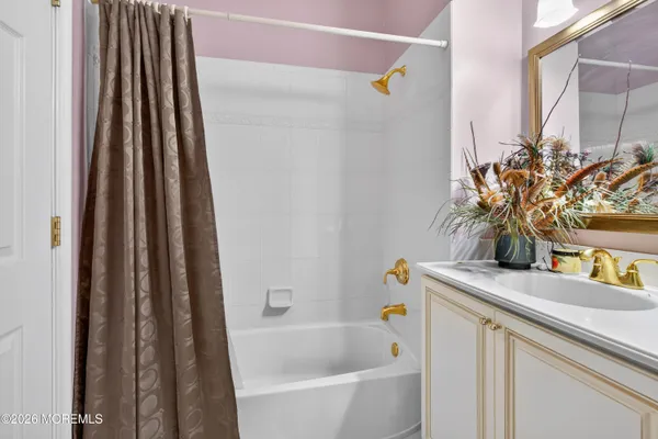 a bathroom with a granite countertop sink and a bathtub