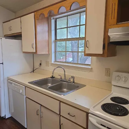 a kitchen with a sink cabinets and a stove top oven