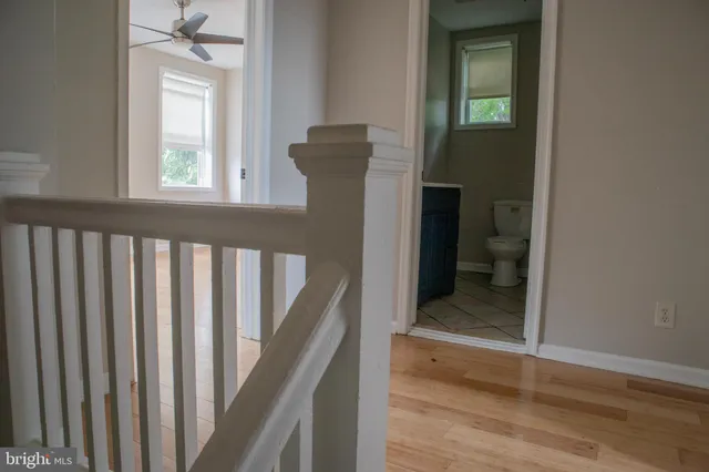 a view of a hallway with wooden floor and staircase
