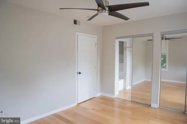 a view of a big room with wooden floor and hallway