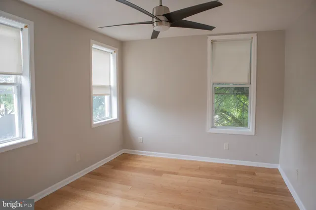 an empty room with a window and wooden floor