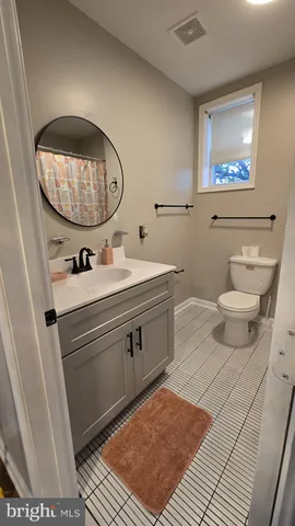 a bathroom with a sink mirror and a toilet