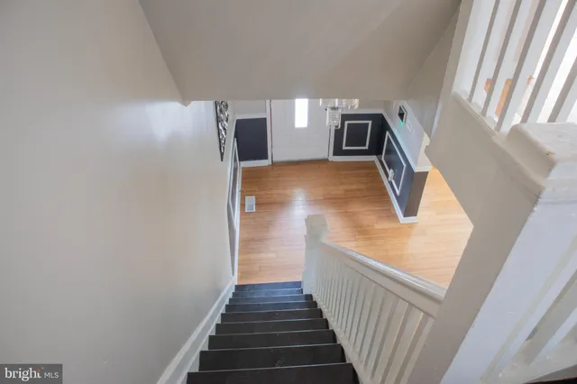 a view of a hallway with wooden floor and staircase