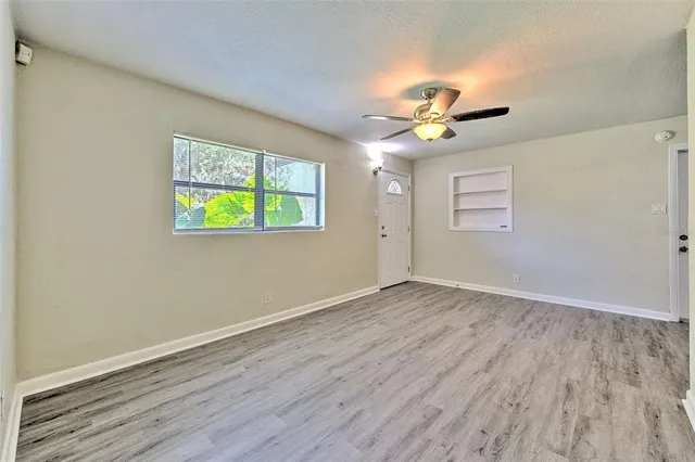 a view of empty room with wooden floor
