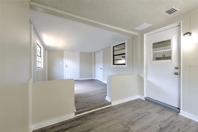 wooden floor in an empty room and a kitchen