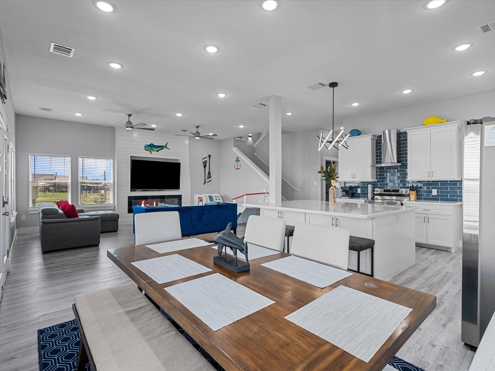 718 Beach Drive Surfside Beach, TX 77541 - Photo 13 of 49 Experience modern elegance in this kitchen with sleek white cabinetry, stainless steel appliances, and a spacious island. Enjoy abundant natural light from large windows and double doors leading to the deck.