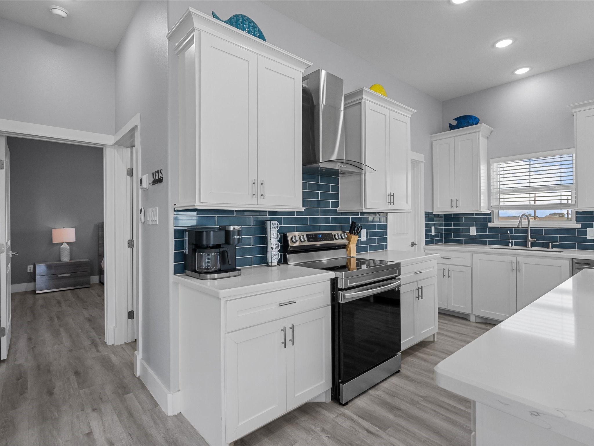 718 Beach Drive Surfside Beach, TX 77541 - Photo 18 of 49 Experience modern elegance in this bright living room, featuring large windows with stunning views, a cozy fireplace beneath a mounted TV, stylish seating, and ceiling fans—ideal for relaxation and entertaining.