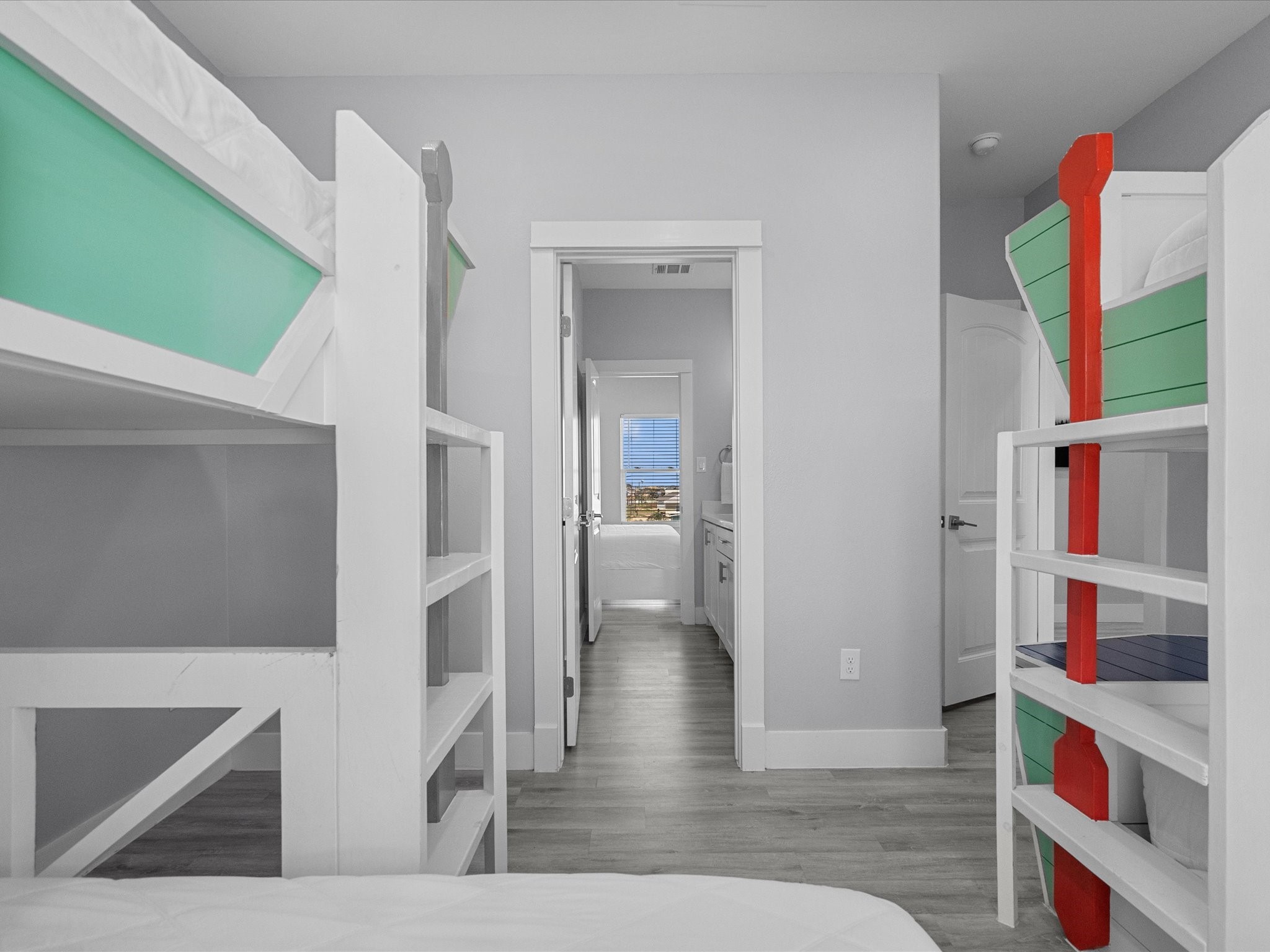 718 Beach Drive Surfside Beach, TX 77541 - Photo 31 of 49 Experience modern comfort in this bedroom featuring light gray walls, a cozy white bed, and a striking yellow armchair. A nautical painting adds charm, while natural light, a ceiling fan, and recessed lighting enhance the ambiance.