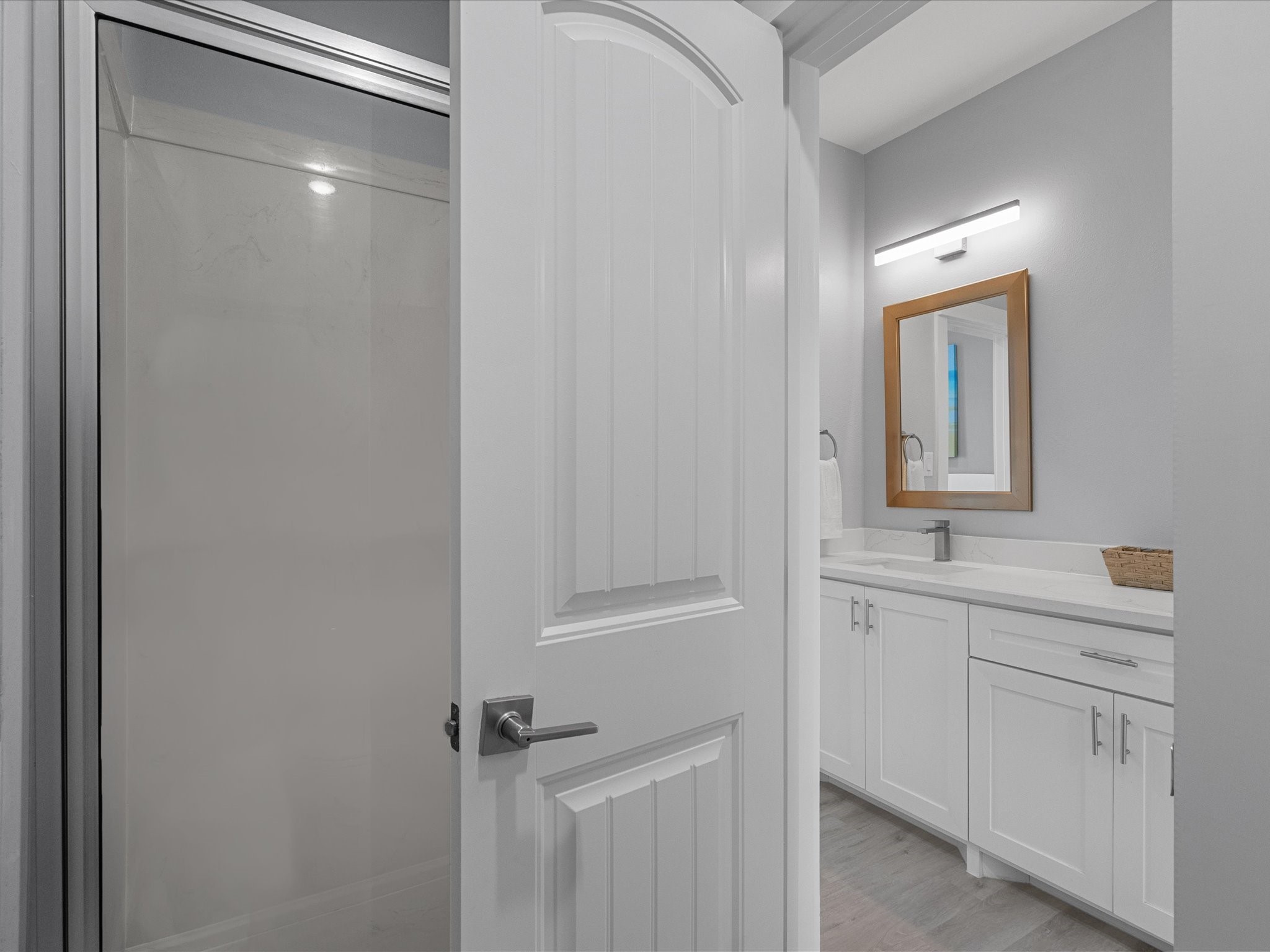 718 Beach Drive Surfside Beach, TX 77541 - Photo 33 of 49 This bright, modern hallway features light wood flooring, recessed lighting, and neutral walls, creating a spacious, airy feel. Enjoy a small vanity area, stairway access, and a door leading to an inviting outdoor deck.