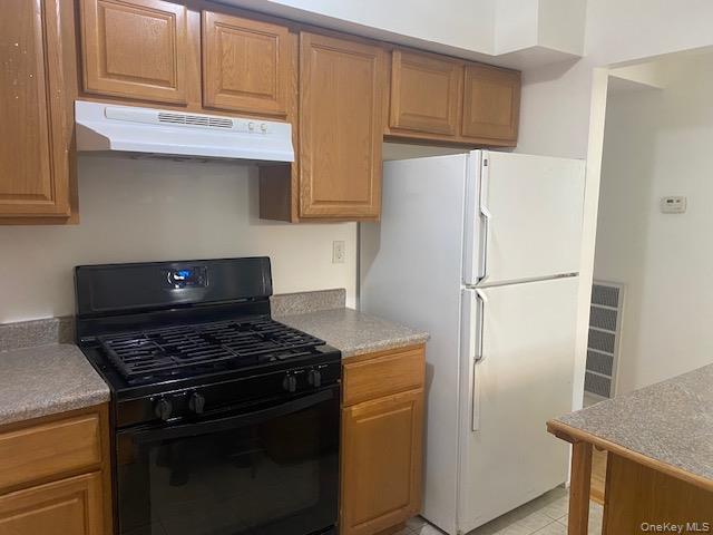 75 Rocky Point Yaphank Road, Unit 133 Rocky Point, NY 11778 - Photo 7 of 15 a kitchen with stainless steel appliances a refrigerator and a stove