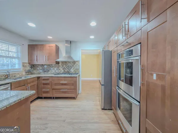 a kitchen with stainless steel appliances granite countertop wooden cabinets and a granite counter tops