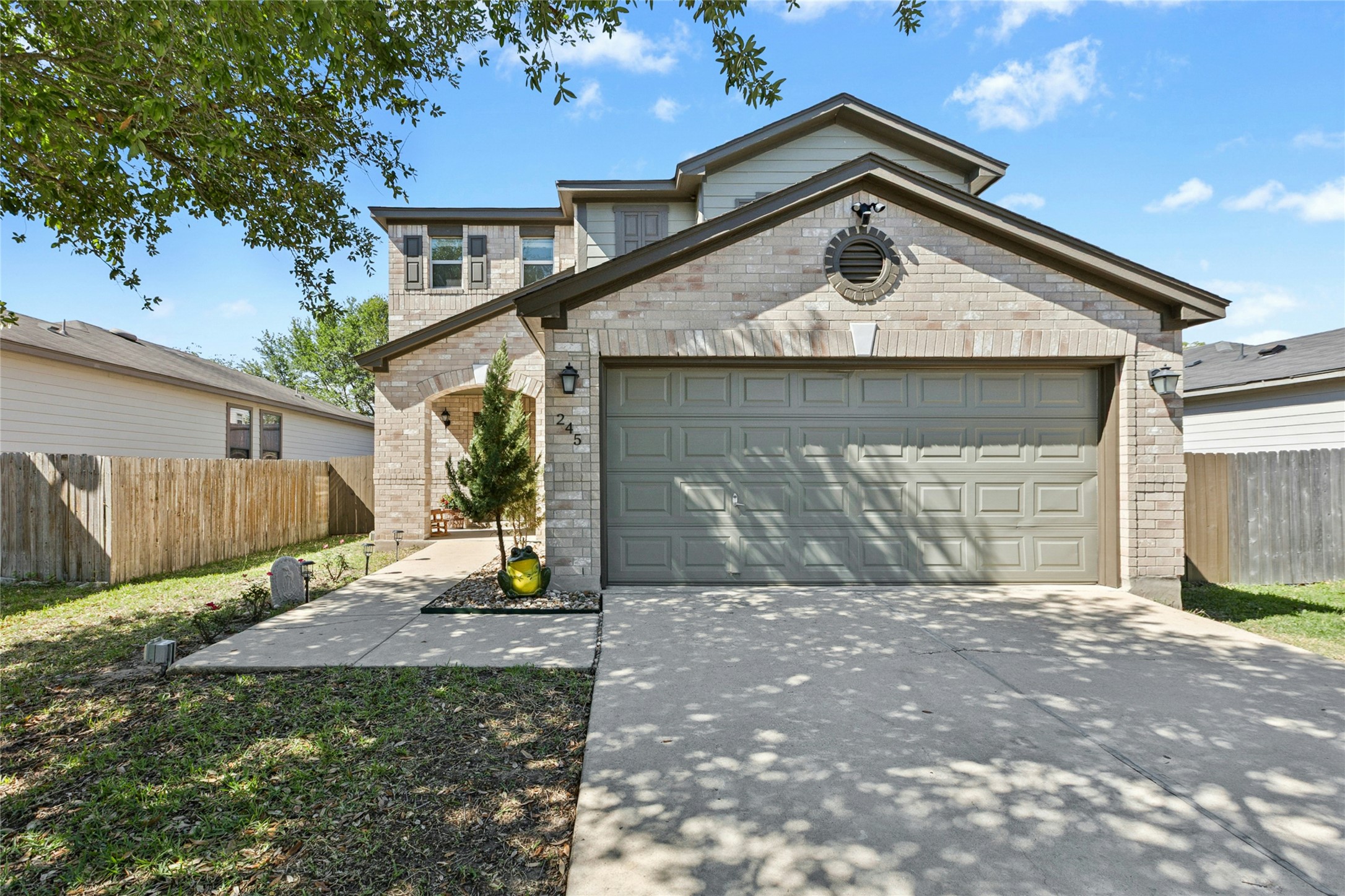 245 Myrtle Street Kyle, TX 78640 - Photo 2 of 24 View of front of home with an attached garage, brick siding, and concrete driveway. New exterior paint.
