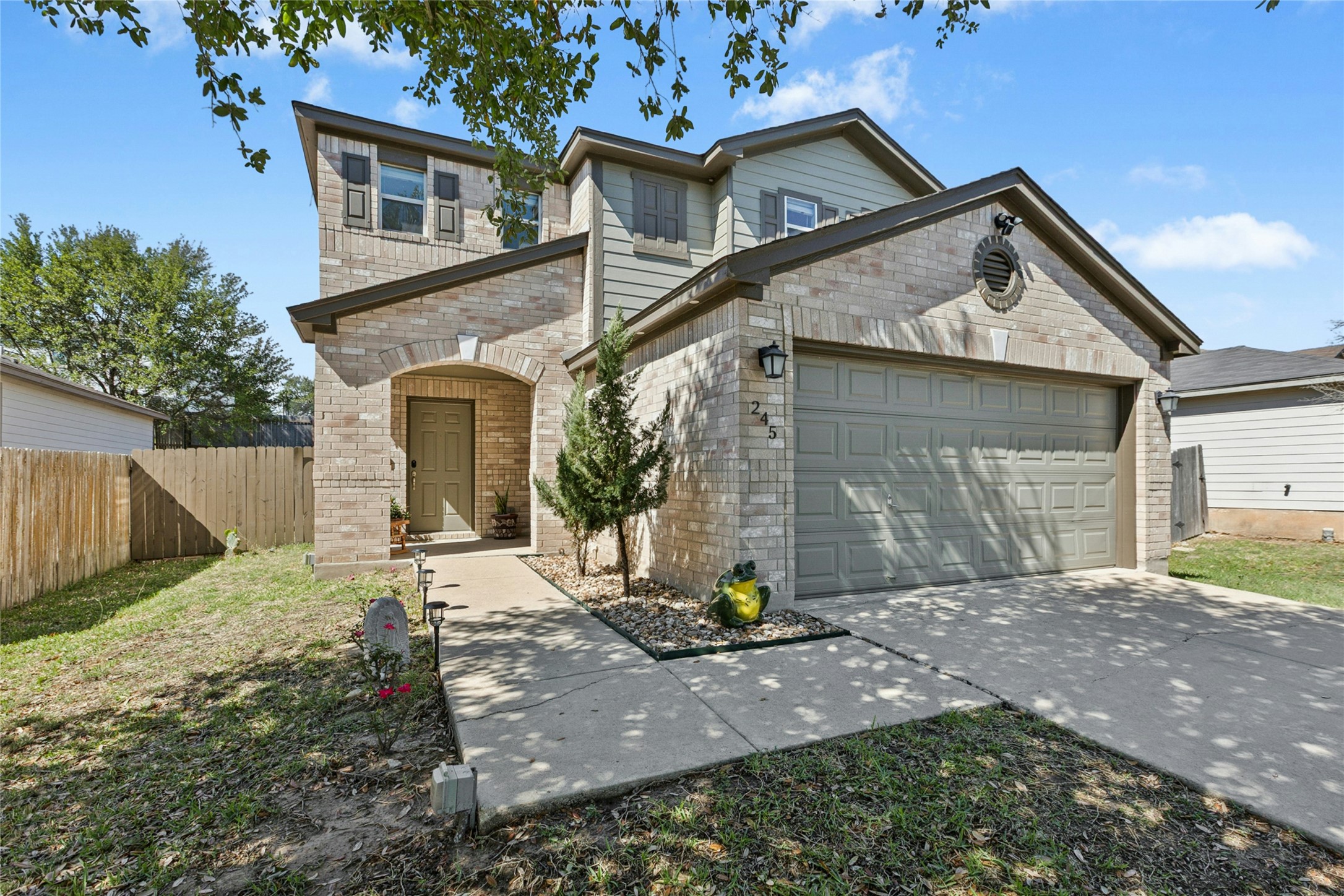 245 Myrtle Street Kyle, TX 78640 - Photo 3 of 24 View of front facade featuring a garage, brick siding, and driveway