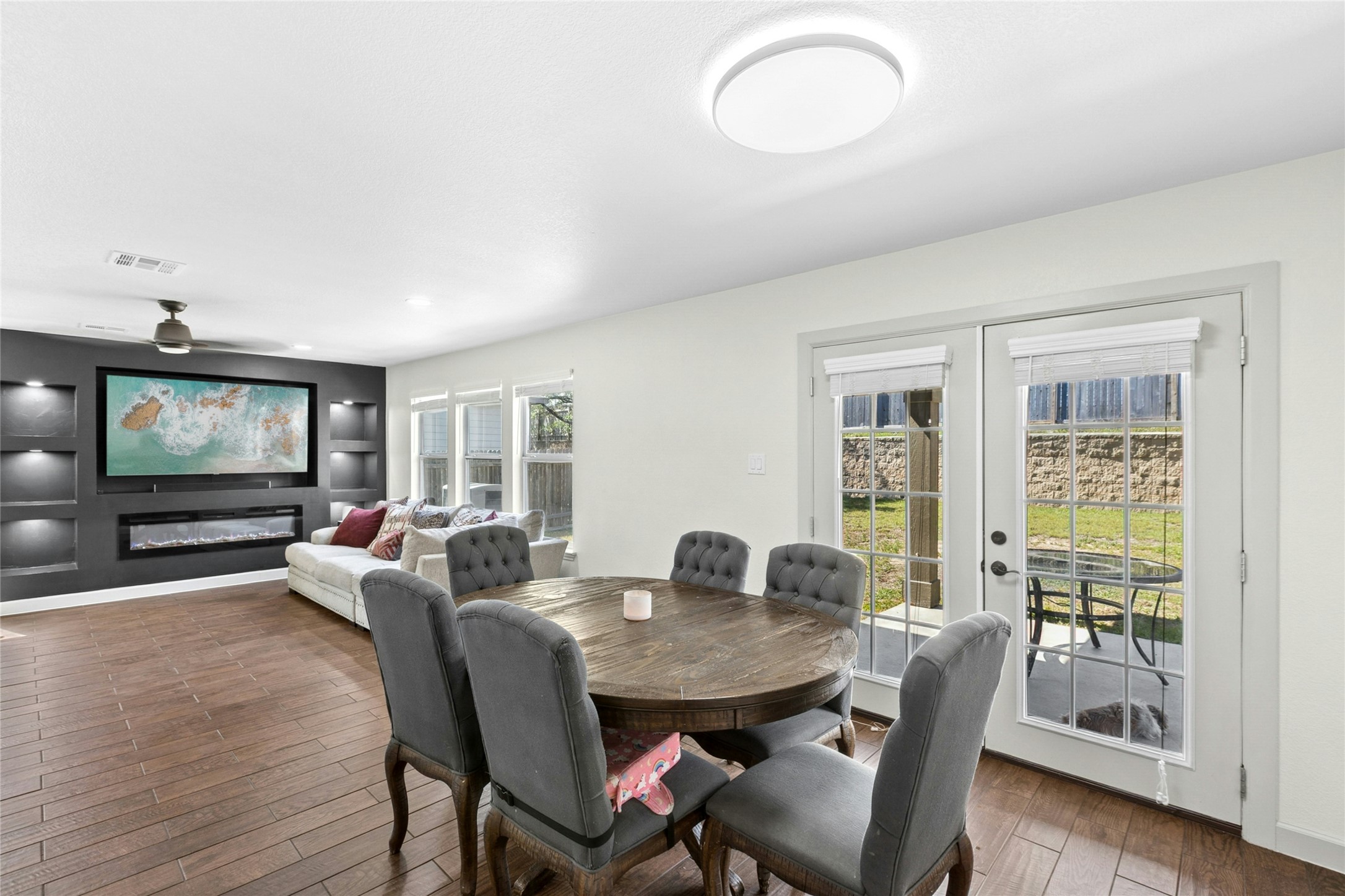 245 Myrtle Street Kyle, TX 78640 - Photo 6 of 24 Dining area featuring french doors, wood-type flooring, and a glass covered fireplace