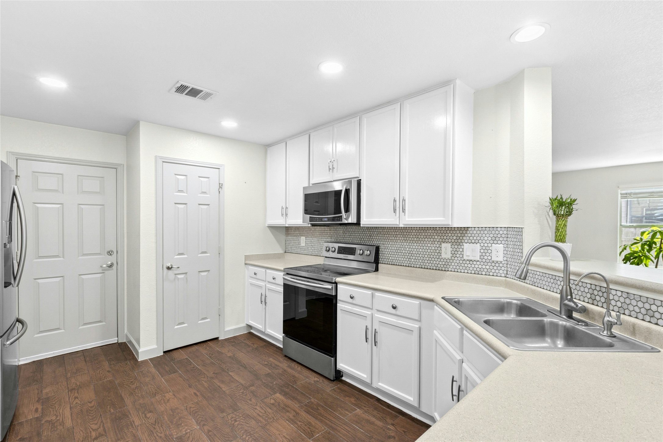 245 Myrtle Street Kyle, TX 78640 - Photo 9 of 24 Kitchen with stainless steel appliances, white cabinets, light countertops, dark wood finished floors, and recessed lighting