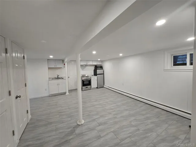 a view of a kitchen with a sink a wooden floor and a stove