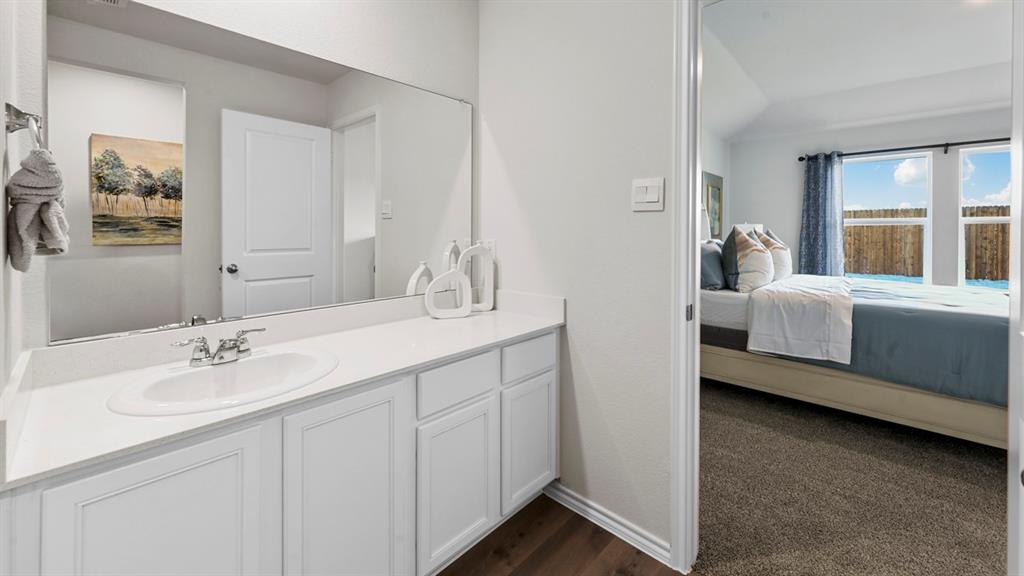 936 Jefferson Way Sherman, TX 75092 - Photo 4 of 31 a en suite bathroom with a double vanity sink a mirror and next to a window