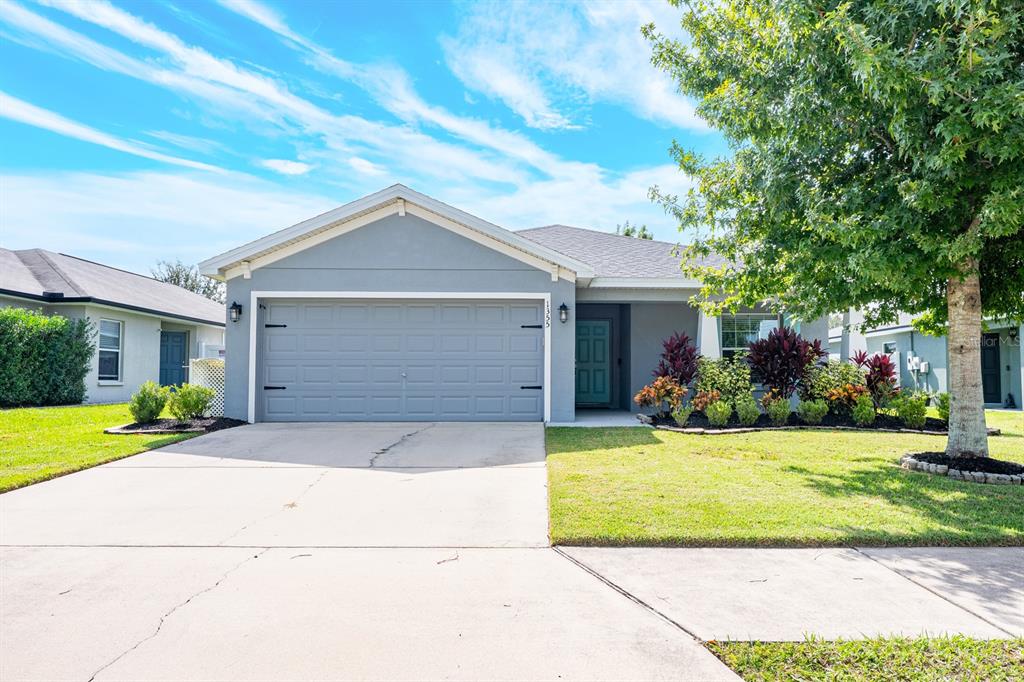 1355 Windward Oaks Loop Auburndale, FL 33823 - Photo 1 of 25 a front view of a house with a yard and garage