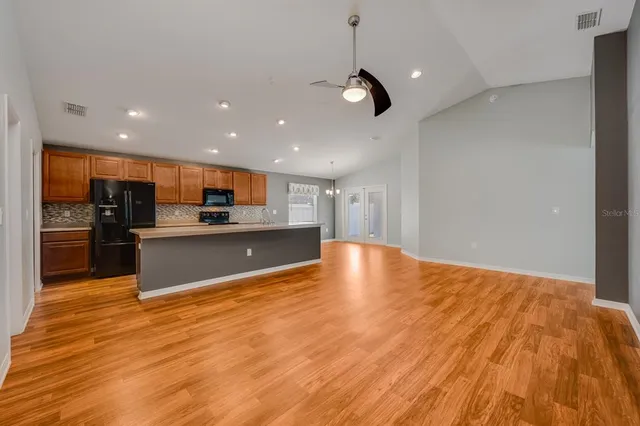 a view of an empty room with window and wooden floor