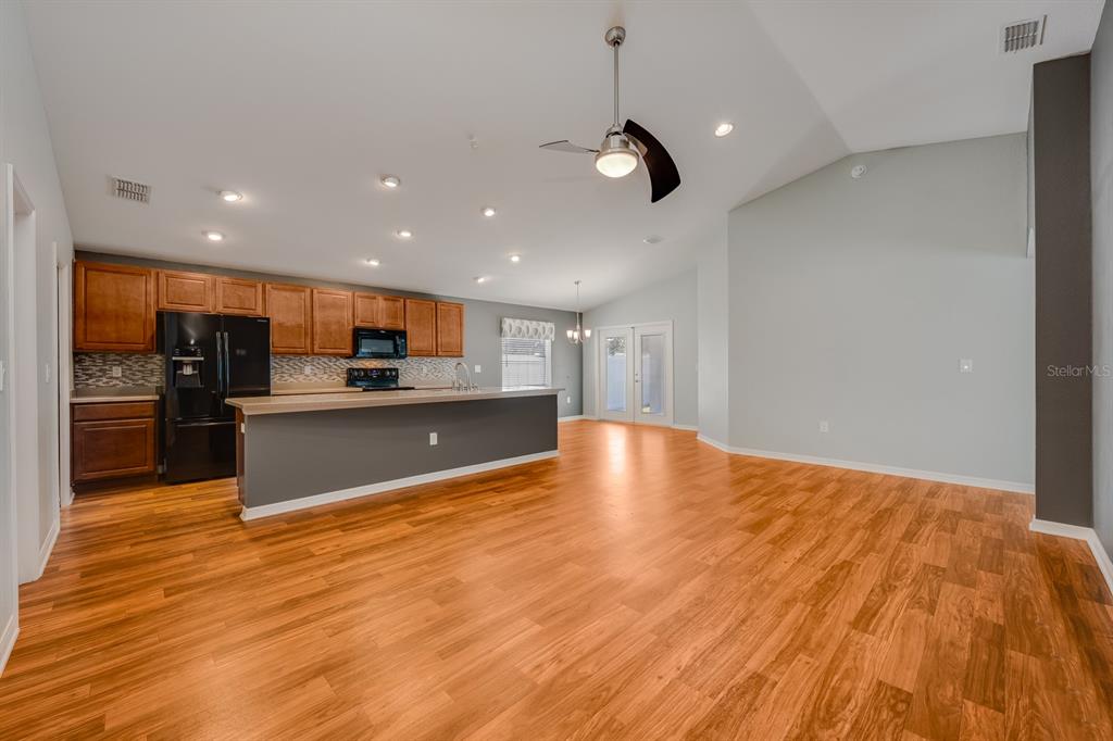 1355 Windward Oaks Loop Auburndale, FL 33823 - Photo 20 of 25 a large kitchen with stainless steel appliances a large counter top a refrigerator and a sink